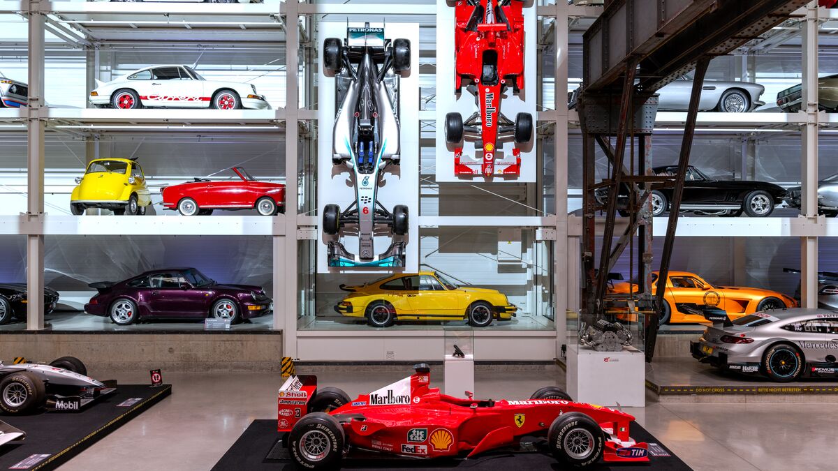 A wall-mounted shelf full of cars in a museum